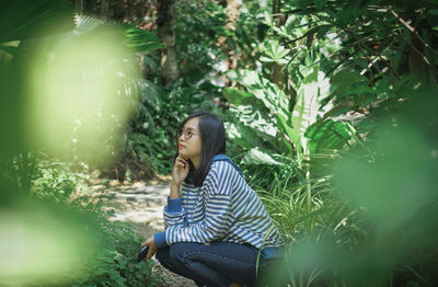 Full length of woman sitting on land