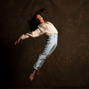 Portrait of woman dancing against white background