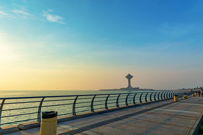 Pier over sea against sky during sunset