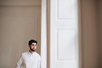 Man standing at doorway in home