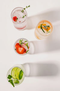 Lemonades with different flavors on the white table, summer refreshing drinks, top view