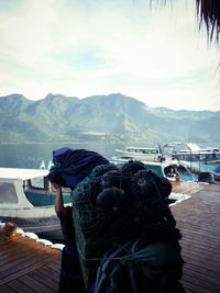 Close-up of man against sea and mountains