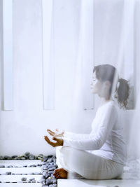 Young woman meditating in balcony