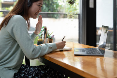 Midsection of woman using laptop on table