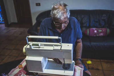 Elderly man using a sewing machine