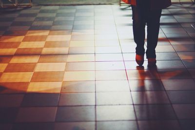 Low section of woman standing on tiled floor