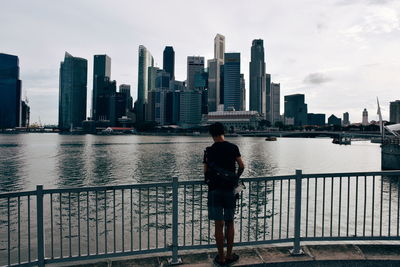Woman standing by river in city