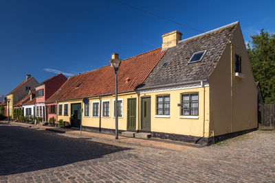 Houses by street against sky in city