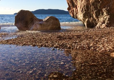 Rocks on beach against sky