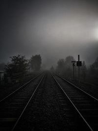 Railroad tracks by trees against sky