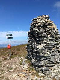 Sign on rock against clear blue sky