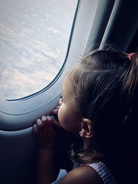 Girl looking through airplane window