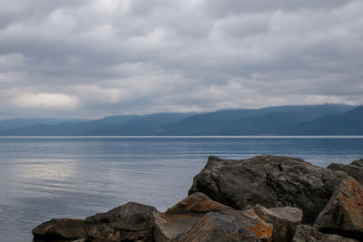  lake baikal in cloudy weather, irkutsk region, russia. in the foreground are large stones.