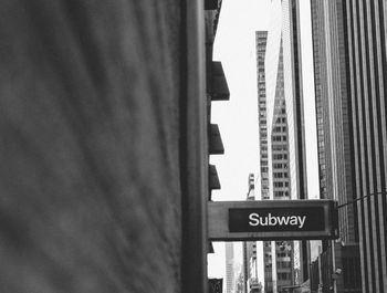 Close-up of road sign against buildings in city