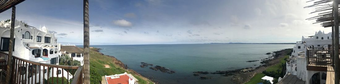 Panoramic view of sea and buildings against sky