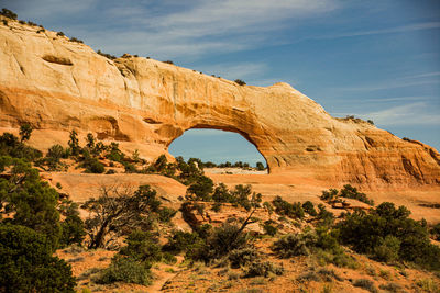 Arch on rock formation against sky