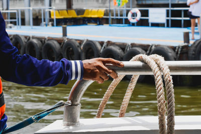 Man holding rope on boat