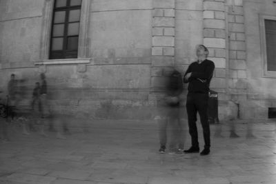 Man and woman walking on sidewalk in city