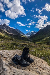 High angle view of shoes on mountain road against sky