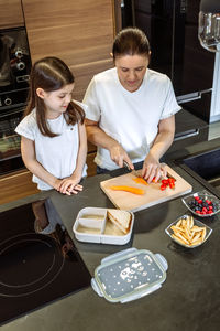 High angle view of woman having food in kitchen