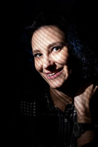 Portrait of smiling woman standing in darkroom