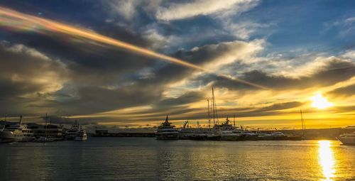 Scenic view of sea against dramatic sky during sunset