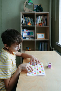 Child playing diy dot game for fingers. useful game for development of childs fingers