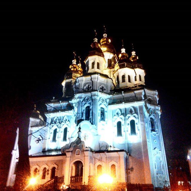 architecture, building exterior, religion, built structure, place of worship, church, low angle view, night, spirituality, illuminated, cathedral, cross, sky, outdoors, facade, no people, lighting equipment, clear sky