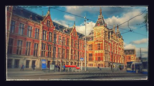 Buildings in city against cloudy sky