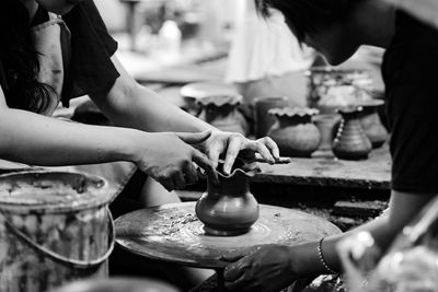 Midsection of women molding pot in workshop