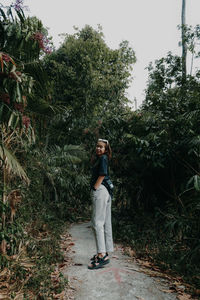 Full length portrait of woman standing on footpath