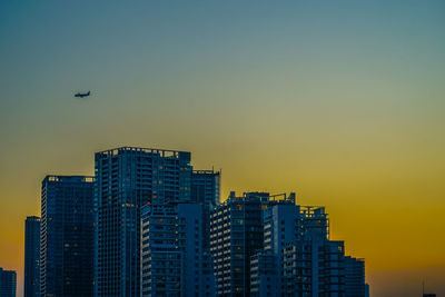 Low angle view of modern buildings against sky during sunset