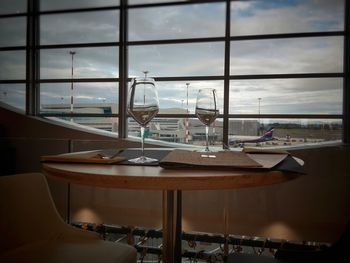 Chairs and table against sky seen through window