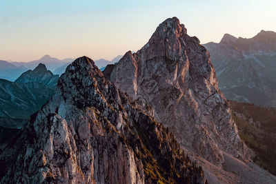 Panoramic view of rocky mountains against sky during sunset