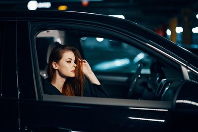 Side view of woman sitting with hand in hair