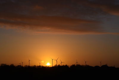 Silhouette of wind turbines at sunset