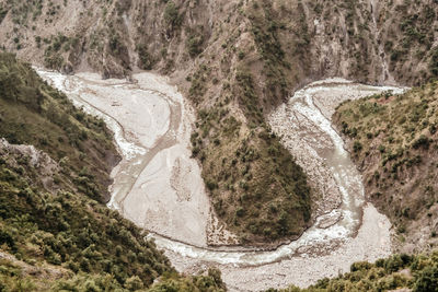 Aerial view of river flowing through mountains