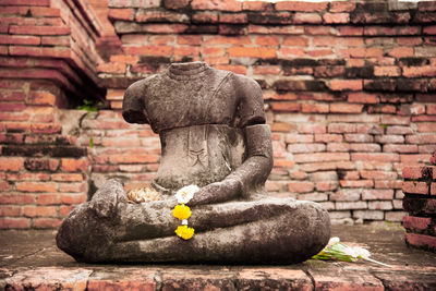 Buddha statue against brick wall