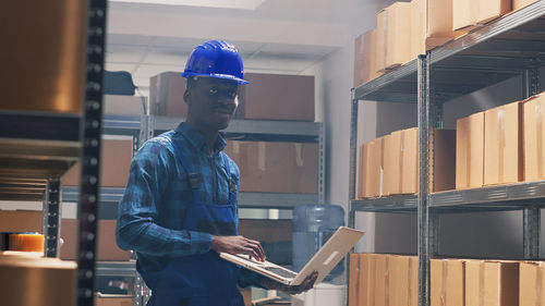 Side view of man standing in factory