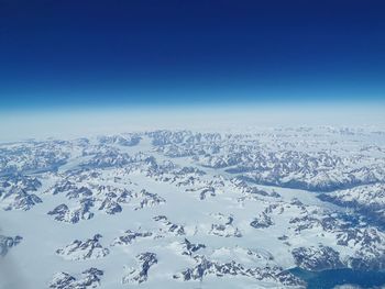 Scenic view of snowcapped mountains against blue sky