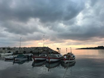 Boats moored in marina at sunset