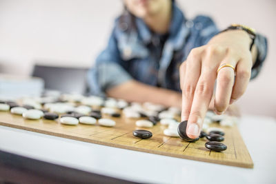 Midsection of man playing board game on table