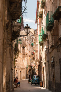 Street amidst buildings in city against sky