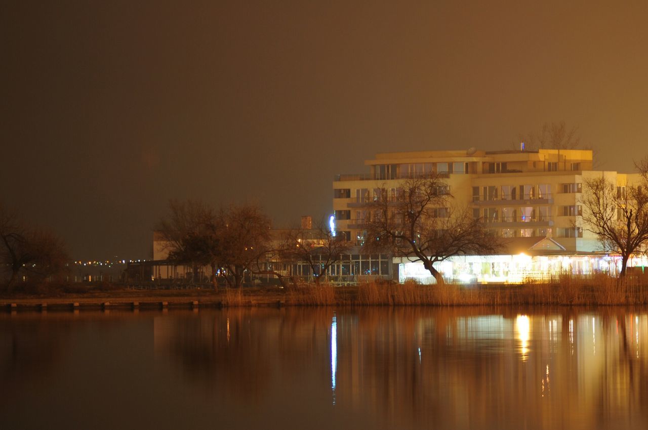 architecture, reflection, water, built structure, building exterior, waterfront, illuminated, lake, river, clear sky, sky, sunset, night, house, copy space, building, outdoors, residential building, dusk, no people