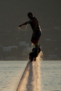 Man flyboarding in sea