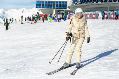 Portrait of woman snowboarding on snow covered land