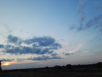 Scenic view of silhouette field against sky at sunset