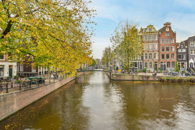 Canal amidst buildings against sky