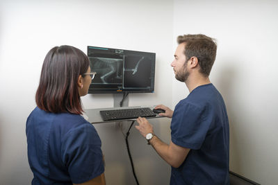 Veterinarians examining x-ray image on computer at clinic
