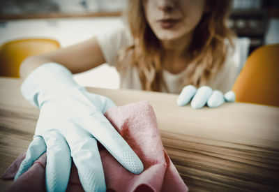 Close-up of woman cleaning table